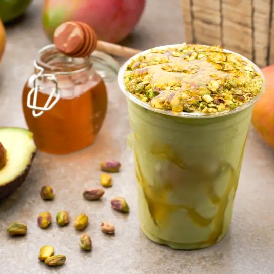 avocado-smoothie-pistachios-drizzle-honey-plastic-cup-side-view-summer-drink-avocado-smoothie-pistachios-402102619